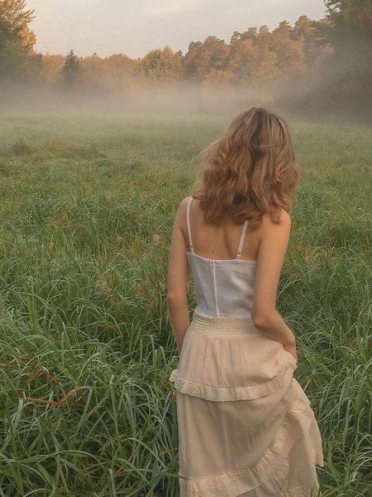 Hình ảnh cô gái tóc ngắn ngồi một mình trên ghế đá, thể hiện sự trầm tư và cô đơn.