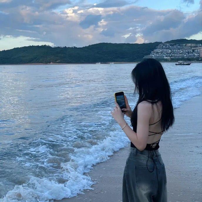 Nữ tóc ngắn tạo dáng ảnh chụp sau lưng đứng quay ra biển thơ mộng