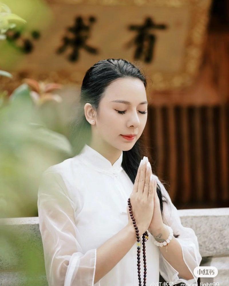 Phật tử đang chắp tay vái Phật trước không gian chùa thanh tịnh