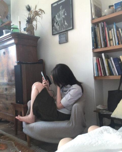 Cô gái với mái tóc đen dài buông xõa che đi một phần khuôn mặt, tạo nét bí ẩn và duyên dáng